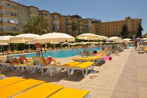 a pool with chairs and umbrellas and people at a resort at Hedef Resort Hotel in Konaklı
