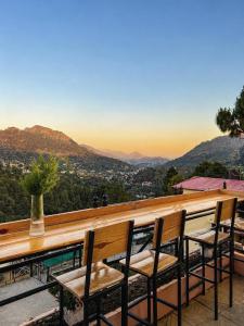 a table and chairs on a balcony with a view at Chetan's Villa in Bhīm Tāl