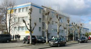 a building on a street with cars parked in front at Lindemann Hotel in Hildesheim