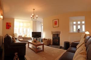 a living room with couches and a fire place at Plas Rhiwlas in Machynlleth