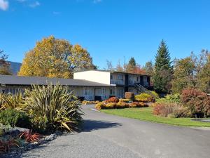a building with a driveway in front of it at Spa Lodge Motel in Hanmer Springs