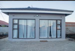 a small house with large glass windows in front of it at MbaliBliss at Selborne in Bulawayo