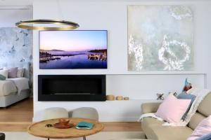 a living room with a couch and a tv at Penthouse On The Promenade in Batemans Bay