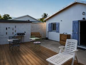 a deck with chairs and a table and a grill at KaZen chez Steph in Petite Île