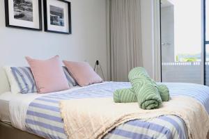 a bed with a stuffed animal on top of it at Penthouse On The Promenade in Batemans Bay