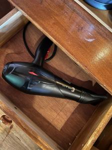 a black hair dryer sitting on a wooden table at Dopi Rinjani Homestay in Tetebatu