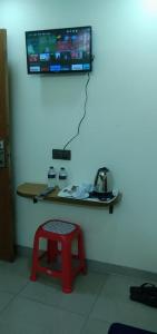 a room with a table and a stool and a monitor at MD HoTEL in Iswardi