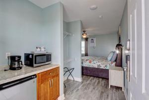 a small kitchen with a microwave and a bedroom at Surf City Stay - Motel Unit - Walk to Beach in Surf City