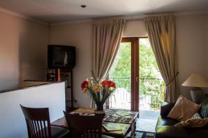 ein Wohnzimmer mit einem Tisch mit Blumen darauf in der Unterkunft Apartment at 34 Columbine Avenue in Johannesburg
