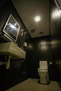 a bathroom with a toilet and a sink and a tv at Hollywood Hotel in Ipoh