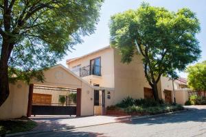 ein Haus mit Garage und Bäumen auf einer Straße in der Unterkunft Apartment at 34 Columbine Avenue in Johannesburg