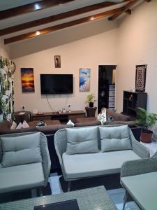 a living room with couches and a flat screen tv at Sunrise Home in Savusavu