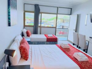 two beds in a room with a window at Tropical Gateway Motor Inn in Rockhampton