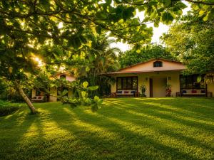 a house with a large lawn in front of it at Los Susurros. Casa in Palenque