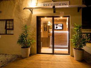 an entrance to a building with two potted plants at Royal Palms Guest House in Port Elizabeth +114 photos