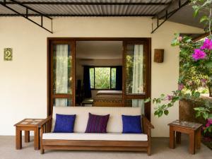 a living room with a white couch and blue pillows at Los Susurros. Casa in Palenque
