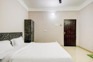 a bedroom with a bed and a door at Hotel O Sai villa in Dispur