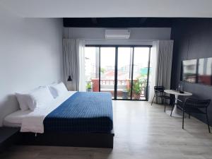 a bedroom with a bed and a view of a balcony at TERREST MAISON On Nut in Bangkok