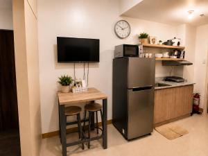 a kitchen with a small table and a refrigerator at Stylish 1BR Condo @ SM Southmall in Manila