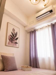 a bedroom with a window with purple curtains at Stylish 1BR Condo @ SM Southmall in Manila +6 photos