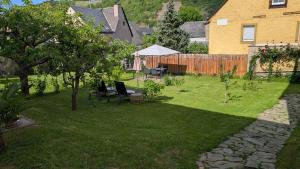 a backyard with a lawn with a table and chairs at Ferienwohnung Ewa in Ellenz-Poltersdorf