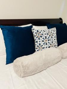 a bed with blue and white pillows on it at New & Modern Suite in Bristol Riverview in Riverview