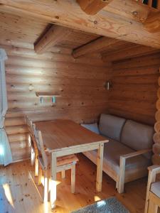 a dining room with a table and a couch at Kotikolo in Inari