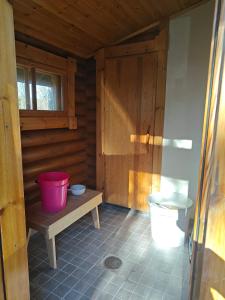 a bathroom with a toilet in a wooden cabin at Kotikolo in Inari +1 photo