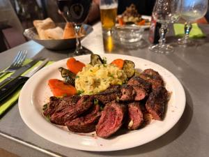 a plate of steak and vegetables on a table at Gadiamb City in Saint-Pierre +25 photos