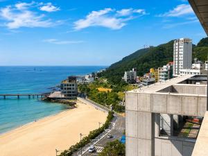 a view of a beach and the ocean from a building at Hotel Laon in Busan