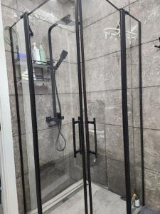 a shower with a glass door in a bathroom at Batumi View apartment in Kachretʼi +3 photos