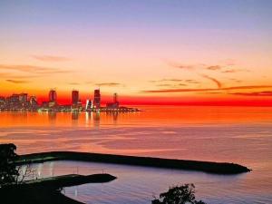 a sunset over a body of water with a city at Batumi View apartment in Kachretʼi