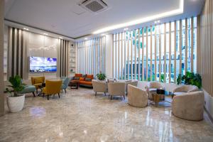 a lobby with a waiting room with chairs and tables at The Royal Palace Uttara in Dhaka
