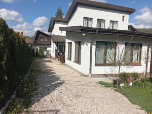a white house with a gravel driveway at ASK MOUNTAIN in Buşteni