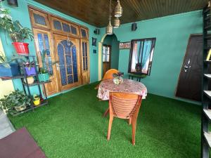 a dining room with a table and green carpet at Y Not Sonada in Sonāda
