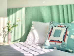 a bed with blue and white pillows and a green wall at Mignon Stay FreeParking Near KSPODome AsanMedicalCenter LotteWorldTower in Samgong