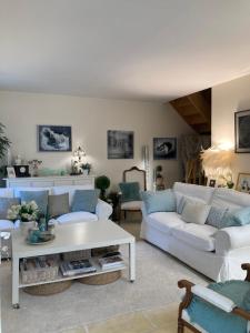 a living room with two white couches and a table at La Maison de Marie in Blaye