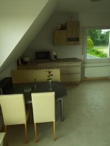eine Küche mit Tisch und Stühlen in einem Zimmer in der Unterkunft Gute Nacht Ferienwohnung in Halle Westfalen