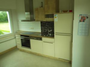 eine Küche mit einem weißen Kühlschrank und einer Spüle in der Unterkunft Gute Nacht Ferienwohnung in Halle Westfalen
