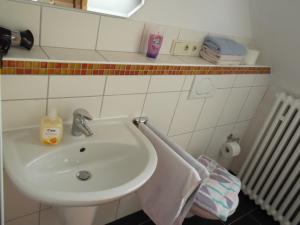 ein Bad mit einem Waschbecken und einem Handtuch in der Unterkunft Gute Nacht Ferienwohnung in Halle Westfalen