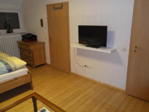 ein Schlafzimmer mit einem Bett und einem Fernseher an der Wand in der Unterkunft Gute Nacht Ferienwohnung in Halle Westfalen