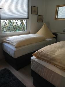 two beds in a bedroom with a window at Messe Ferienwohnung Düsseldorf Oberkassel in Düsseldorf