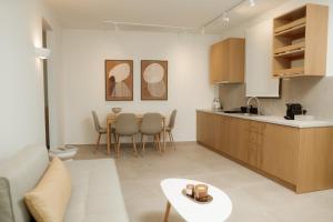 a kitchen and living room with a couch and a table at Aktis Seaside Living in Iraklitsa