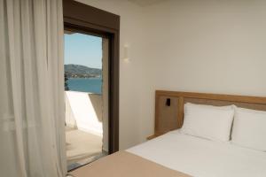 a bedroom with a bed and a view of the ocean at Aktis Seaside Living in Iraklitsa +97 photos