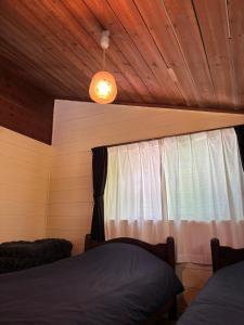a bedroom with a bed and a window at LAKE FOREST hug pug in Yamanakako