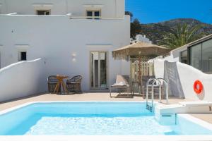 a villa with a swimming pool and a patio at Lithos Suites Sifnos in Kamares