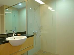 a bathroom with a sink and a glass shower at D'Kalpa Hotel Demangan Yogyakarta in Yogyakarta +16 photos