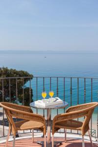 una mesa y sillas en un balcón con vistas al océano en Villa Lucia, en Tučepi