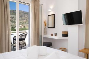 a bedroom with a bed and a view of a balcony at Lithos Suites Sifnos in Kamares +72 photos