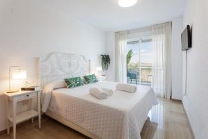 a white bedroom with a bed and a balcony at Ag Aiguablava in Gandía +291 photos
